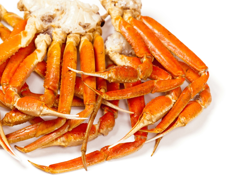 Shot of clusters of crab legs against a white background. 