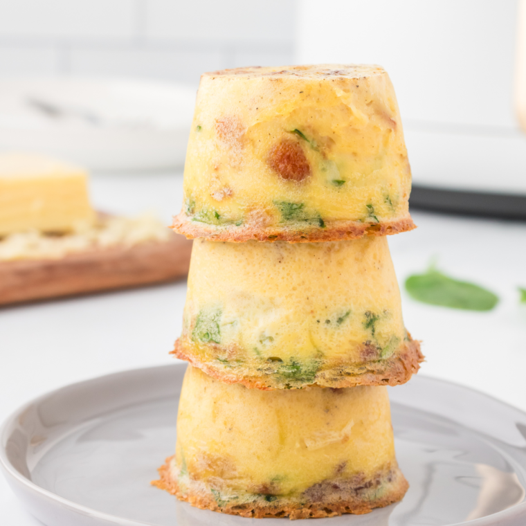 Instant Pot Keto Egg Bites on a plate, cut in half to reveal their soft and cheesy interior."