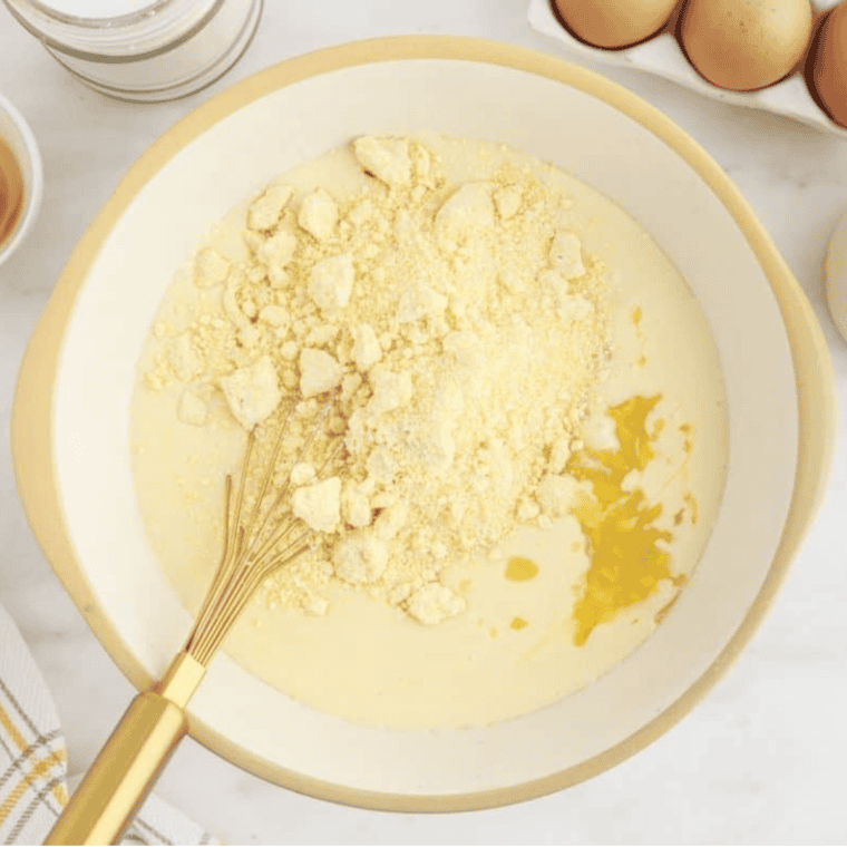 Adding creamed corn, drained whole corn, and Jiffy Cornbread Mix to the bowl and stirring until fully combined.