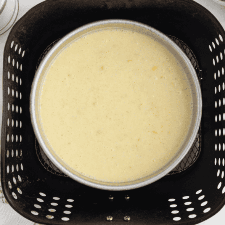 Pouring the cornbread mixture into a baking dish, covering with aluminum foil, and cooking in the air fryer at 320°F for 50-55 minutes until the center is set.