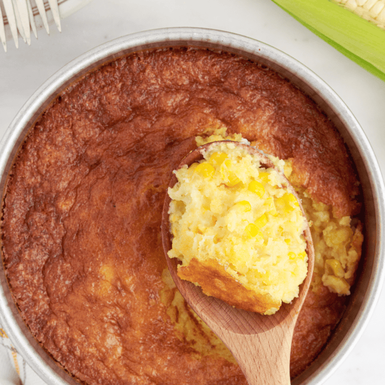 A golden, fluffy Air Fryer Corn Casserole with a crispy top, served in a baking dish.