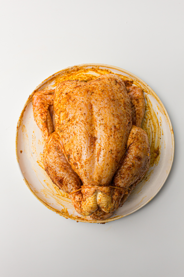 Rub seasoning under skin and over entire chicken evenly