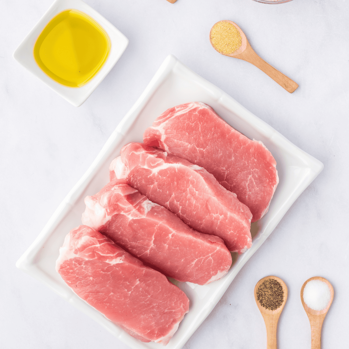 Ingredients needed for Air Fryer Barbecue Pork Chops on kitchen table.