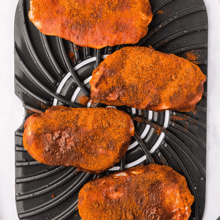 Seasoning the pork chops with olive oil, garlic powder, onion powder, salt, and pepper.