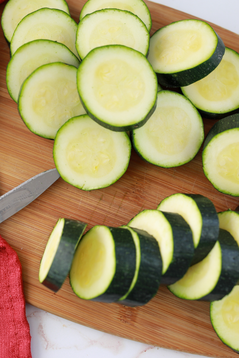 Slicing fresh zucchini into even 1/3-inch thick rounds for air fryer cooking