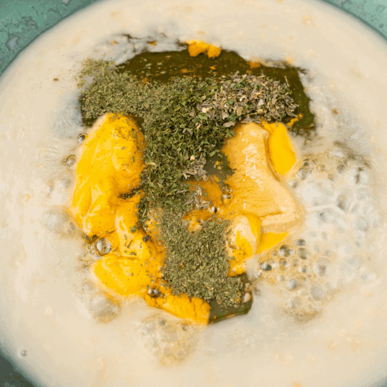 Creamy Dijon sauce simmering in a pan made with chicken broth, mustard, and heavy cream.