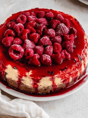 Slice of Cheesecake Factory Lemon Raspberry Cream Cheesecake with raspberry swirls and lemon topping.