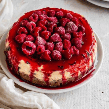 Slice of Cheesecake Factory Lemon Raspberry Cream Cheesecake with raspberry swirls and lemon topping.