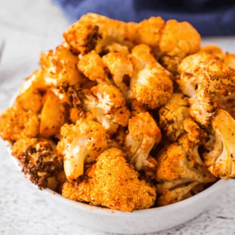Crispy, golden air fryer cauliflower served on a plate, seasoned and ready to eat.
