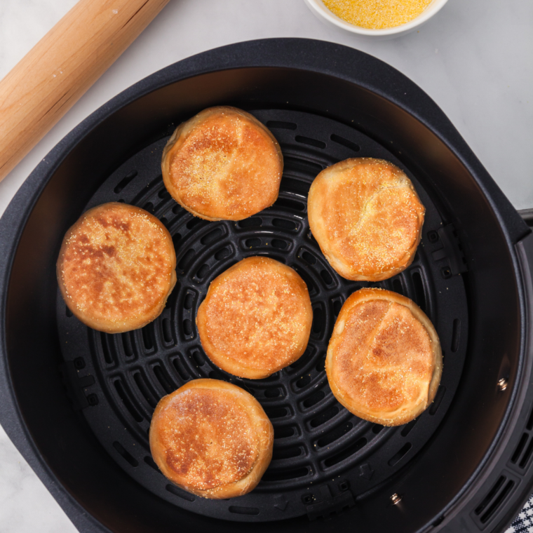 Air fryer English muffin cooking for 3-5 minutes until golden and crispy, ready to be topped with butter, jam, or favorite spread.