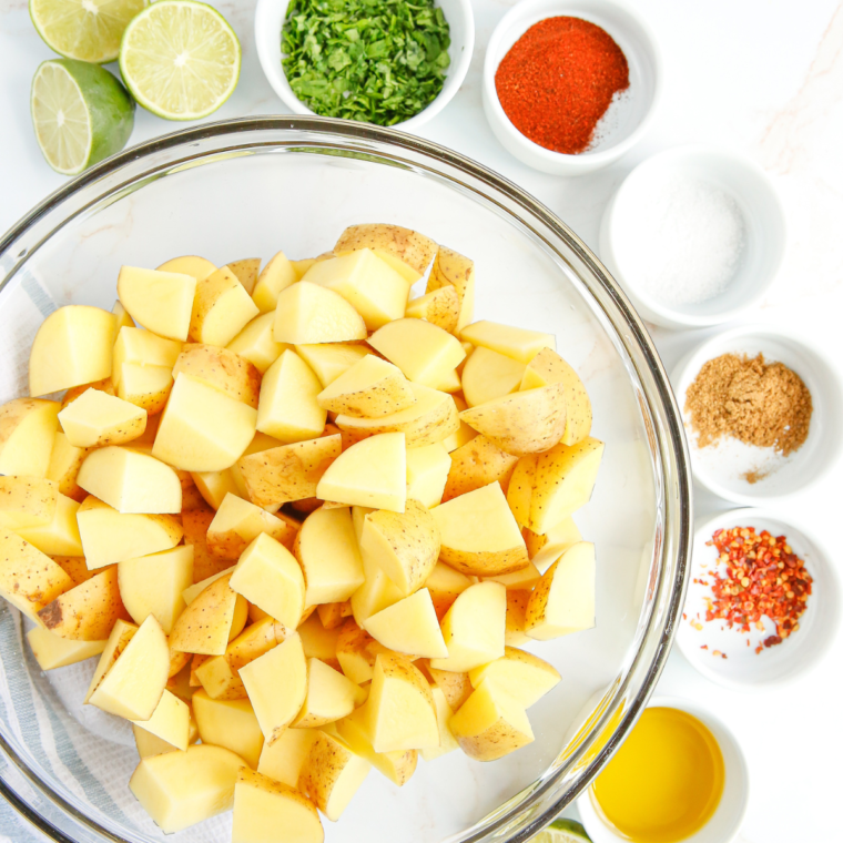 Ingredients needed for roasted potatoes in the air fryer on a kitchen table. Laid out, and measured.