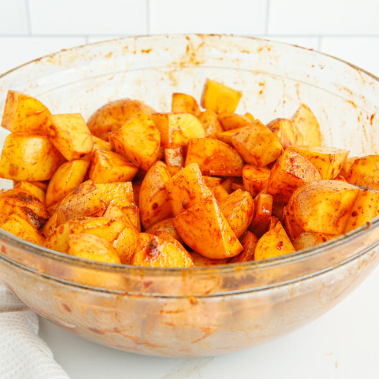 Tossing potato pieces with lemon, rosemary, and seasoning.