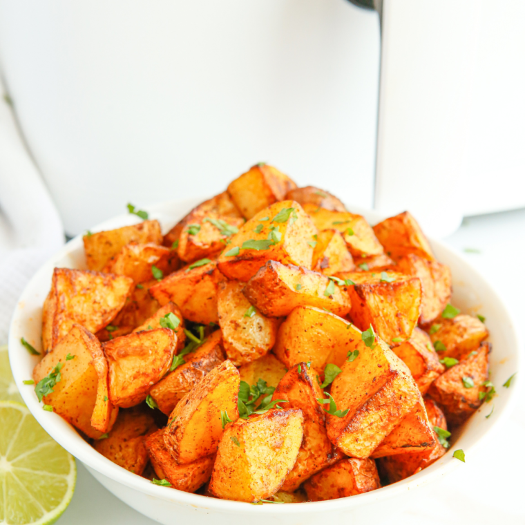 Serving finished Air Fryer Lemon and Rosemary Roasted Potatoes on a plate."