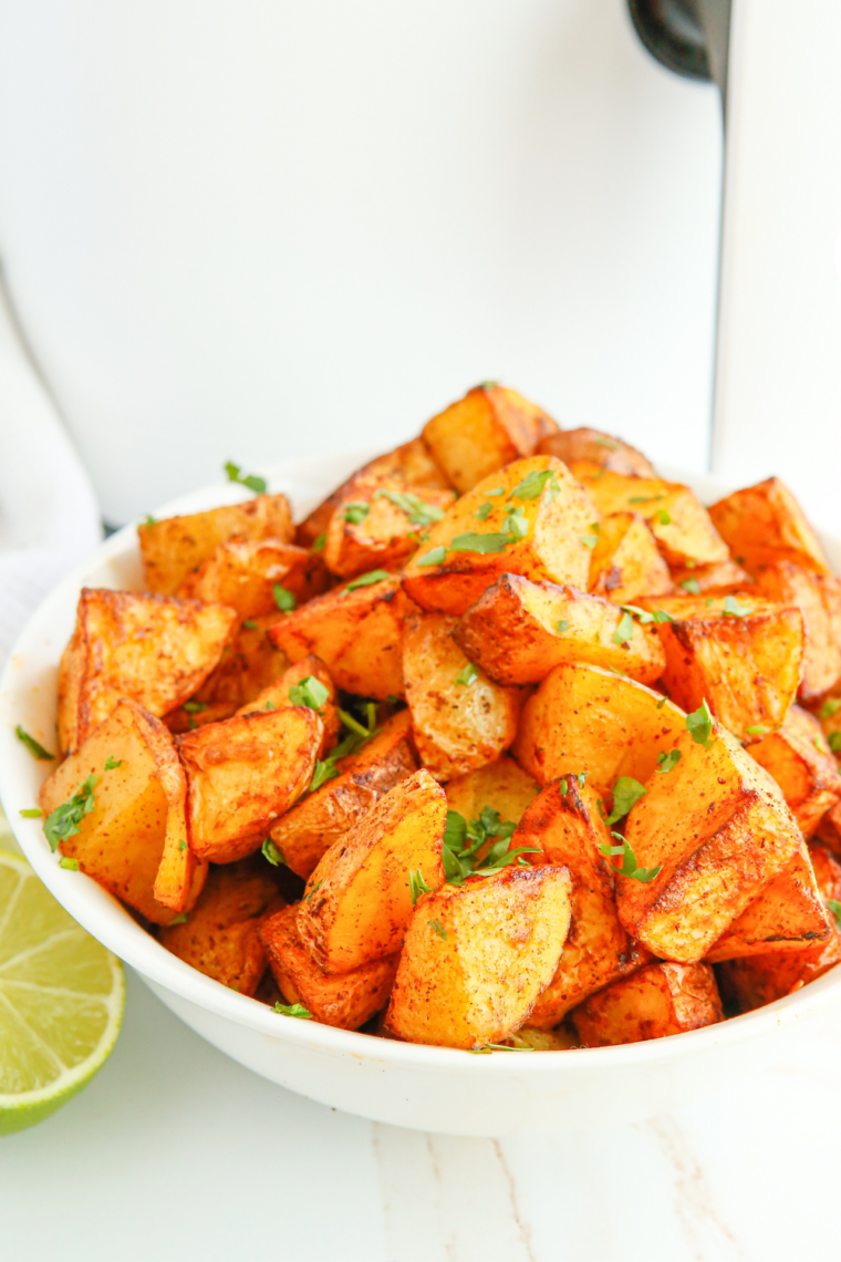 "Crispy Air Fryer Lemon and Rosemary Roasted Potatoes arranged beautifully on a white plate, garnished with fresh rosemary."