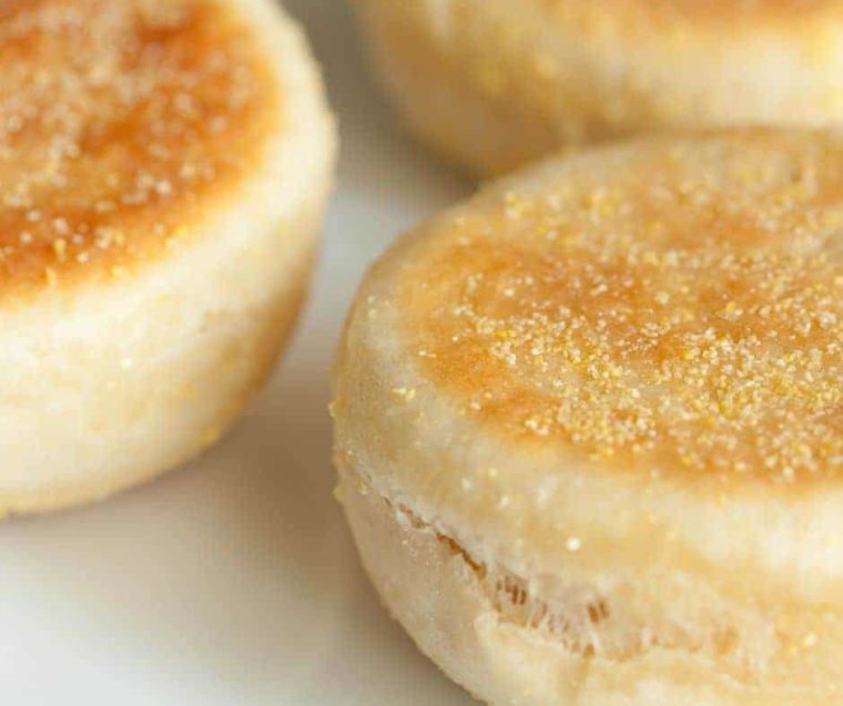 extreme closeup: several english muffins on a counter before slicing