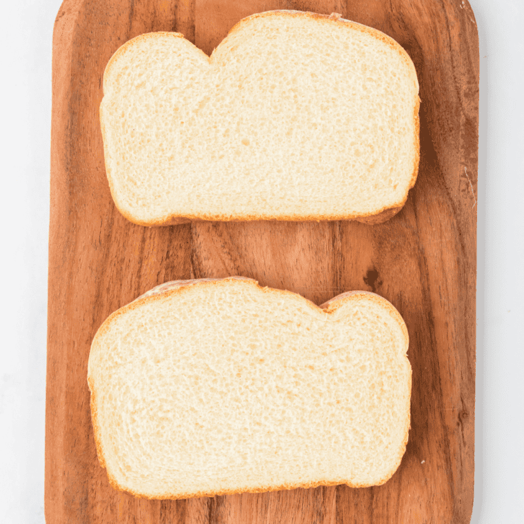 2 Pieces of Bread on cutting board.