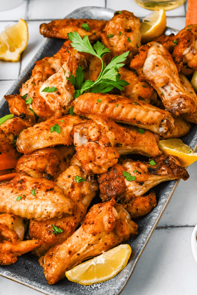 Golden crispy frozen chicken wings cooked in air fryer basket with crunchy skin and hot steam rising.