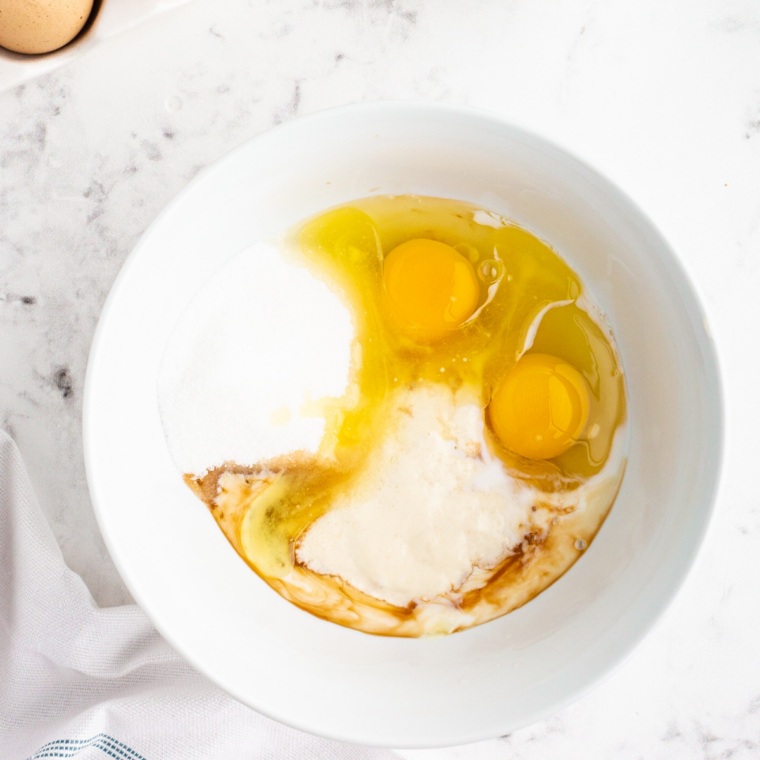Whisking eggs, milk, oil and melted butter together for blueberry muffin batter
