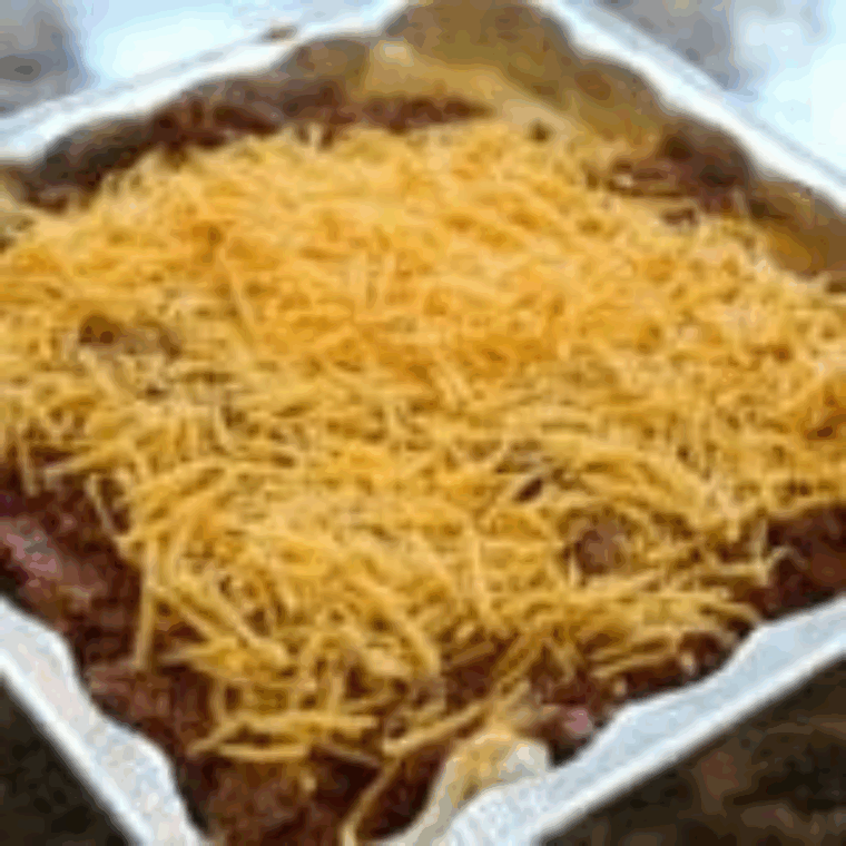 Sprinkling shredded cheddar cheese over the beef layer