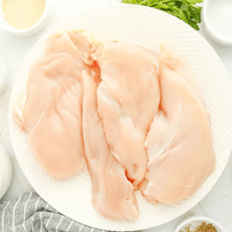 Ingredients for Texas Roadhouse Herb Crusted Chicken Recipe displayed on a countertop, including chicken breasts, herbs, spices, and oil.