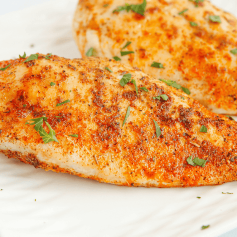 Texas Roadhouse Herb Crusted Chicken plated and garnished with fresh herbs, showcasing its crispy golden-brown crust and juicy chicken.