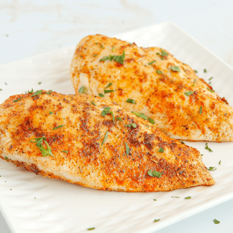 Deliciously seasoned Herb Crusted Chicken from Texas Roadhouse, garnished with fresh herbs and served on a plate.