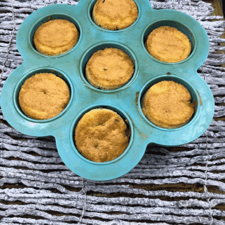 Inserting a toothpick into the center of an air fryer blueberry muffin to check doneness