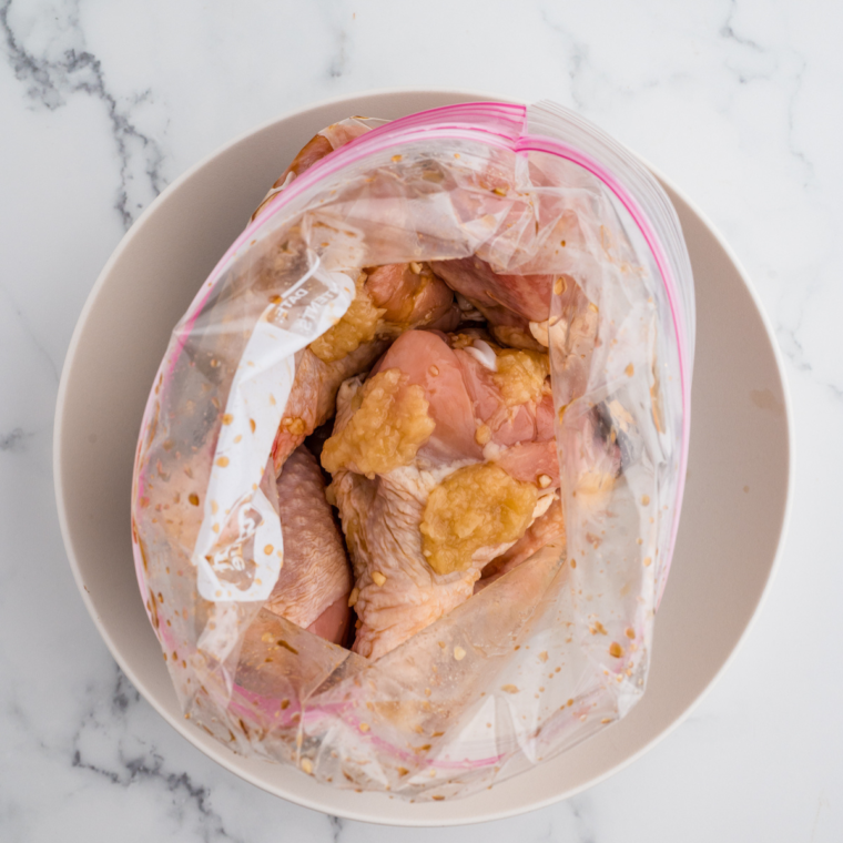 Marinated chicken drumsticks in a bowl, ready to be placed in the air fryer basket for cooking