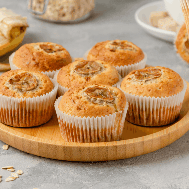 Freshly baked banana cardamom muffins on a wire rack, golden brown with a soft, fluffy interior.