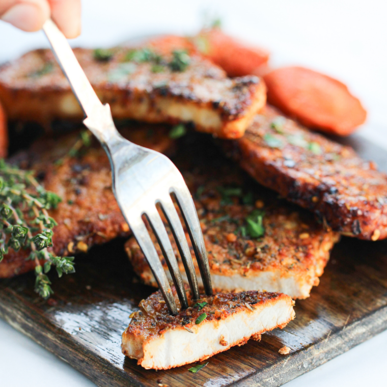 Golden-brown pork steaks plated with sides, ready to eat