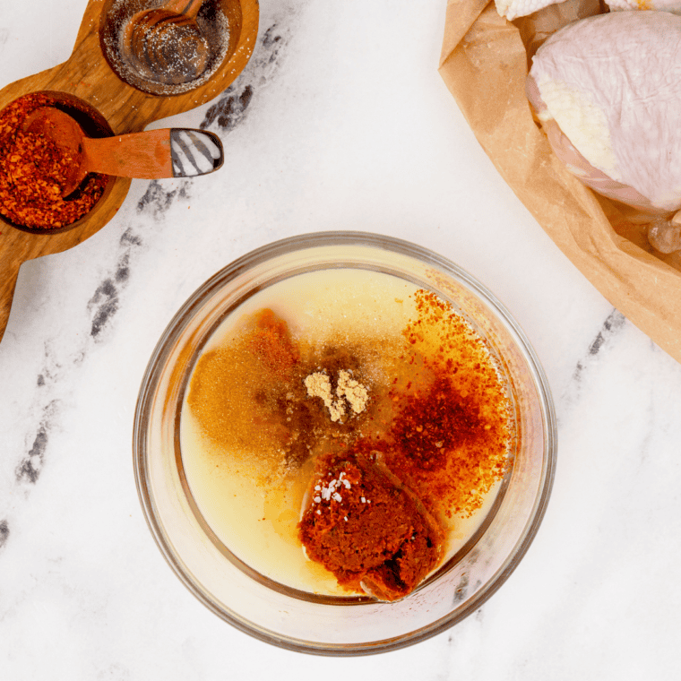 Small bowl of mixed spice rub with paprika, garlic powder, onion powder, salt, pepper, and cayenne for seasoning chicken