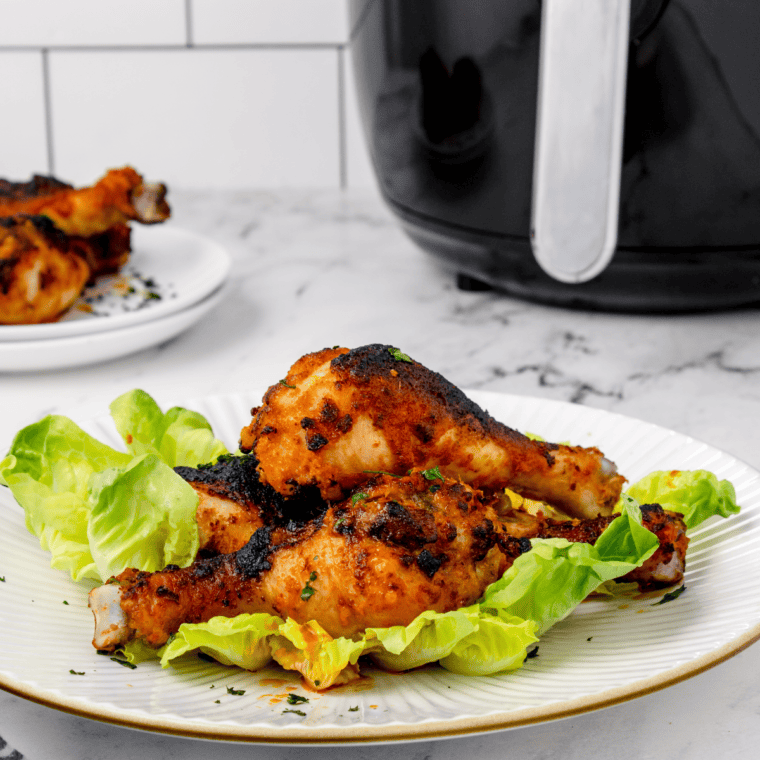 Golden crispy buffalo chicken drumsticks fresh from the air fryer with spicy sauce glaze