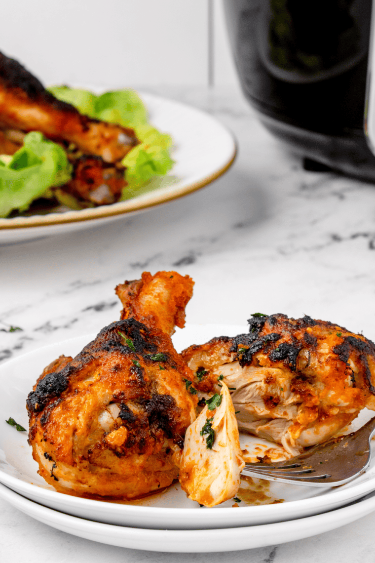 Close-up of crispy air fryer buffalo drumsticks coated in sauce with crunchy skin