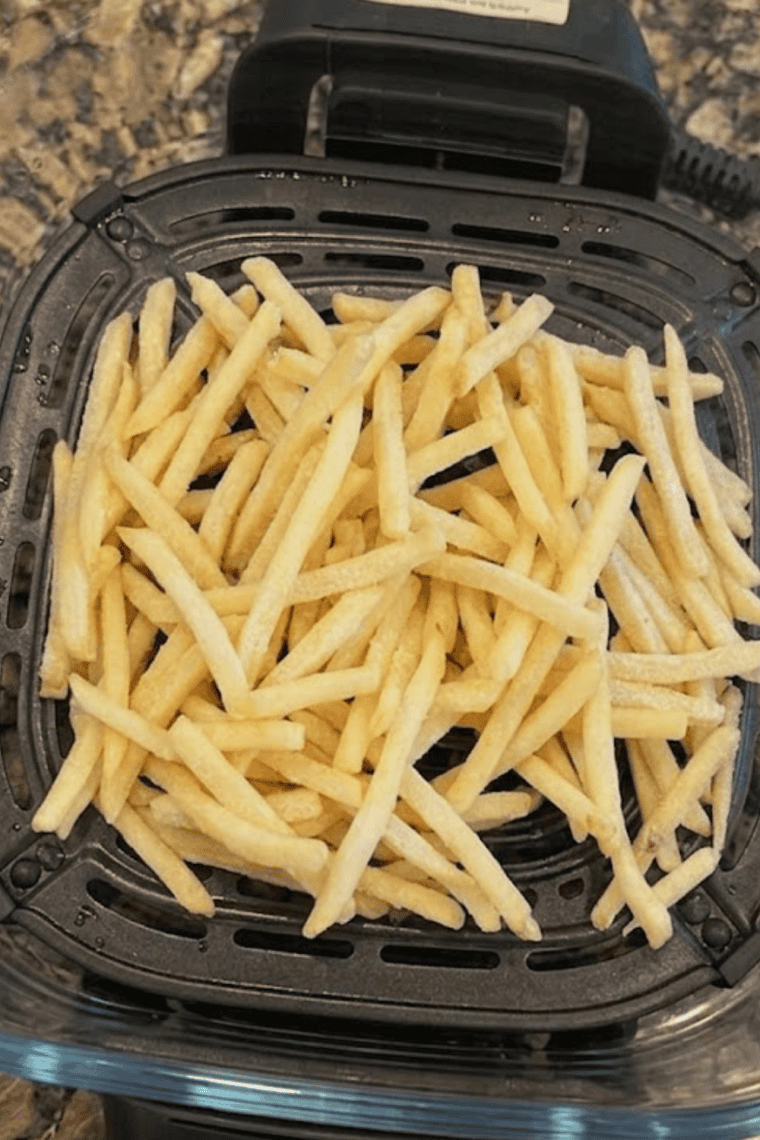 Fries sprinkled with salt, pepper, and paprika, ready for seasoning.