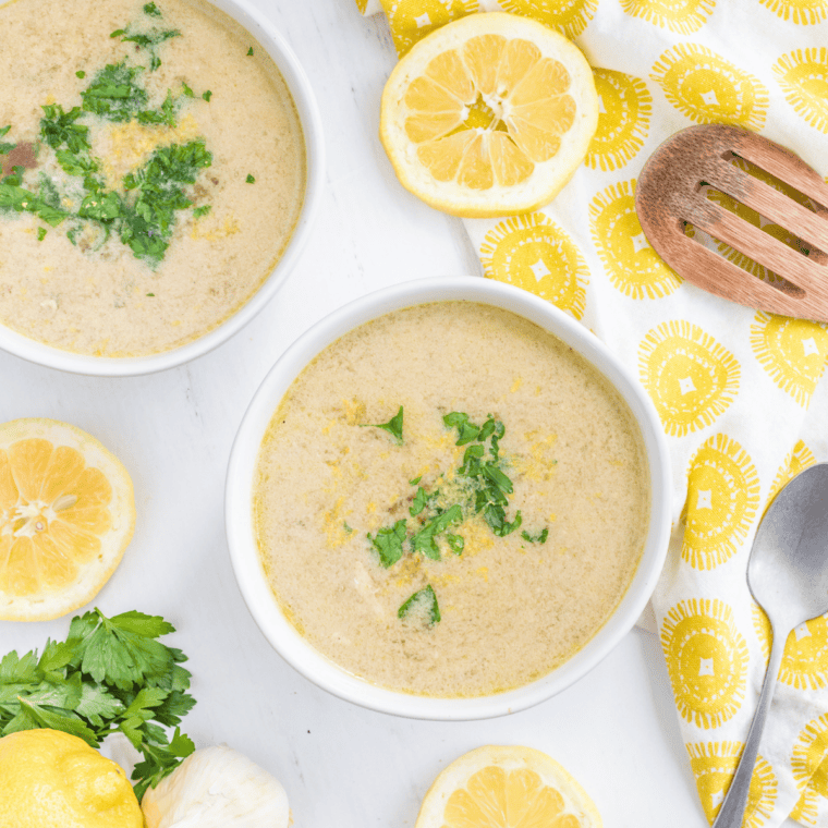 Finished Instant Pot Greek lemon chicken soup in a bowl, topped with fresh dill, lemon zest, and feta