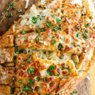 Air fryer cheesy garlic bread rolls topped with golden melted mozzarella and Italian seasoning on a wooden board