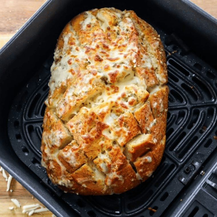 Air fryer cheesy garlic bread rolls fresh from the air fryer basket with melted mozzarella on top