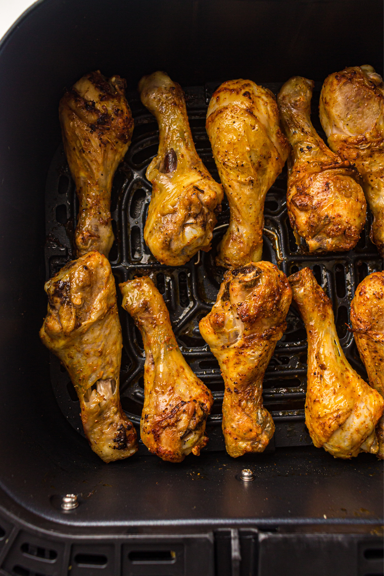 Crispy air fryer garlic paprika chicken drumsticks on a plate with a side salad
