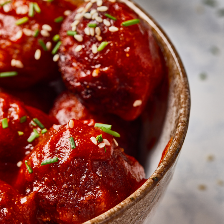 Air fryer hoisin meatballs with a darkened, tightened glaze after four minutes at 350°F
