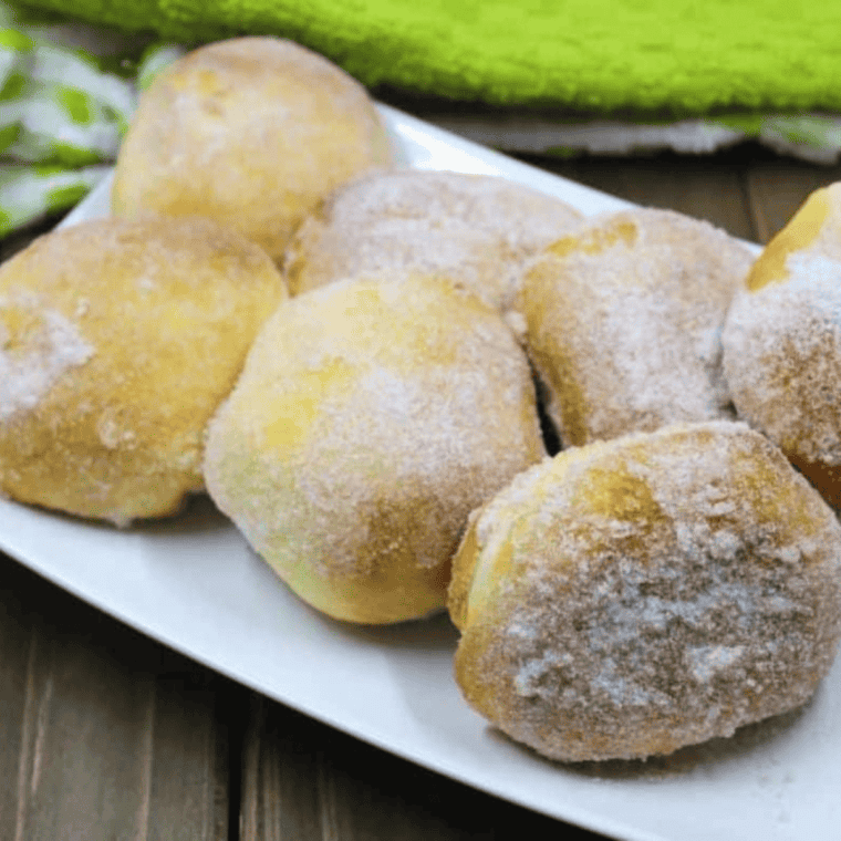 Finished cinnamon sugar apple stuffed donut on a cutting board, ready to serve
