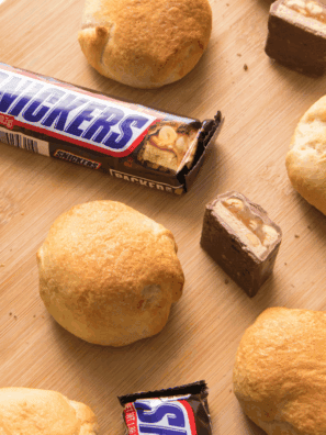 Air fryer Snickers bars with a golden crust, melted chocolate and caramel oozing out.