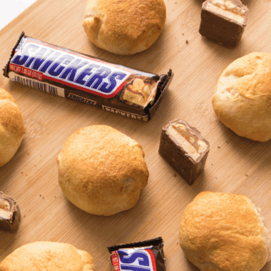 Air fryer Snickers bars with a golden crust, melted chocolate and caramel oozing out.