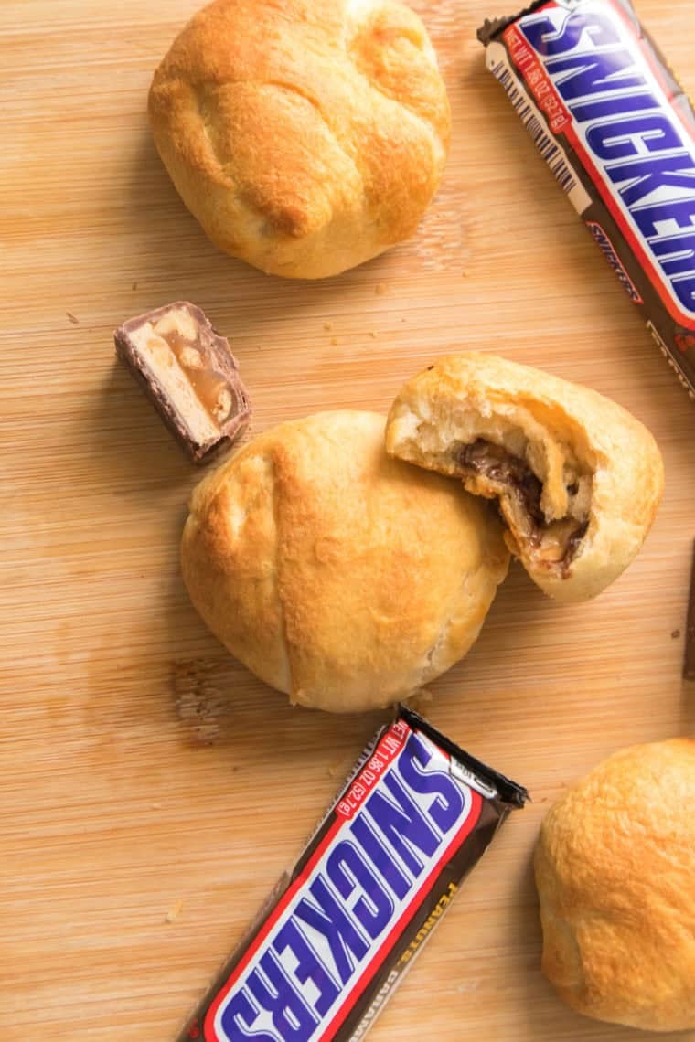 Golden air fryer Snickers Bars cut open, showing melted chocolate and caramel filling.