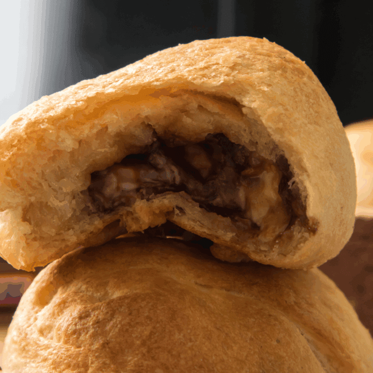Air-fried Snickers bars wrapped in golden biscuit dough, cut open to reveal gooey chocolate and caramel.