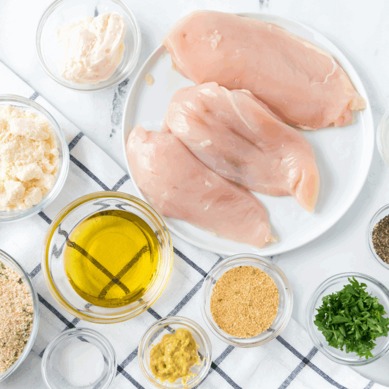 Ingredients needed for Carrabba’s Parmesan Crusted Chicken Arugula Recipe on kitchen table.