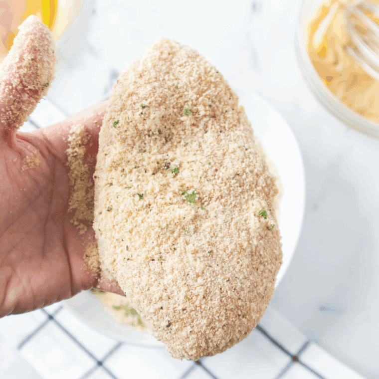 Bread the chicken, and press the coating on the chicken.