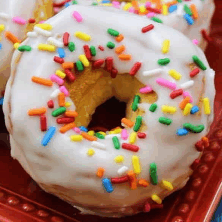 Freshly baked Dunkin’ Donuts sprinkle donuts with glaze and rainbow sprinkles.