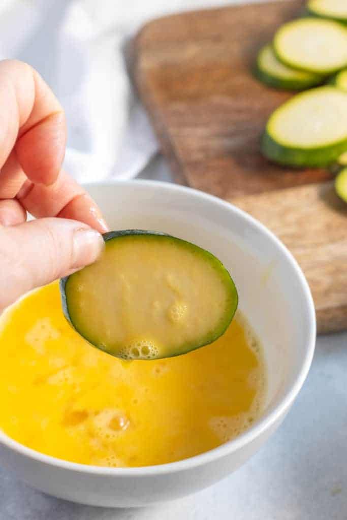 dipping zucchini into egg mixture