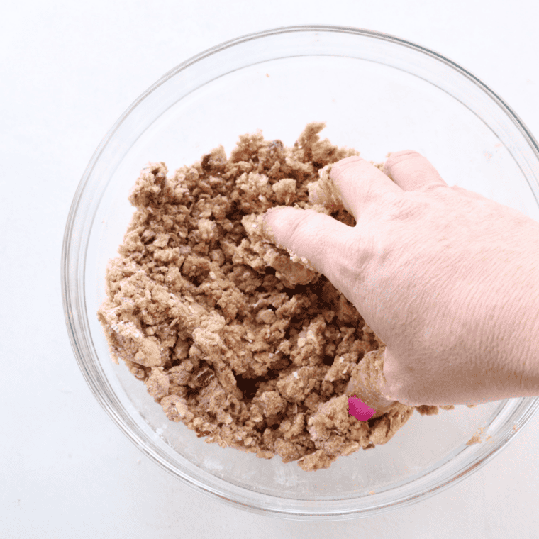 Mixing the oat crumble topping with a fork until it forms coarse clusters