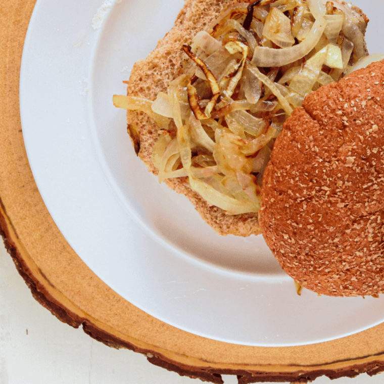 Air fryer Chicago-style pork chop sandwich cut in half, showing the juicy pork and golden onions